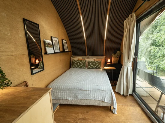 Wnętrze domku glamping sypialnia z łóżkiem dwuosobowym